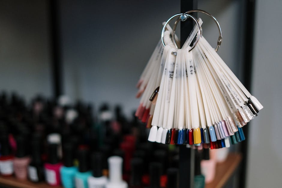 Colorful nail polish samples on display in a modern beauty salon, flanked by assorted bottles