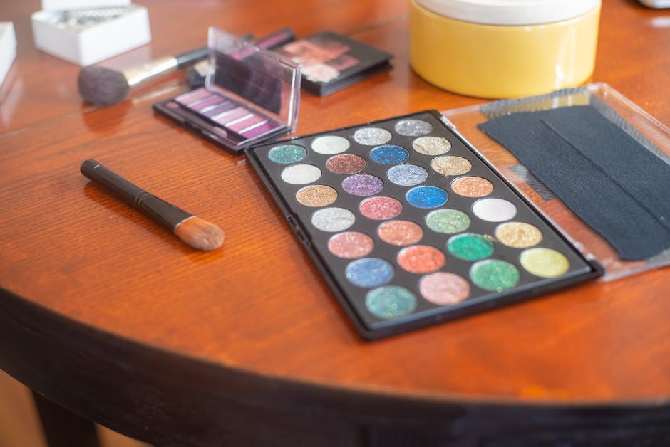 Vivid eyeshadow palette with vibrant colors on a wooden table, ideal for makeup professionals