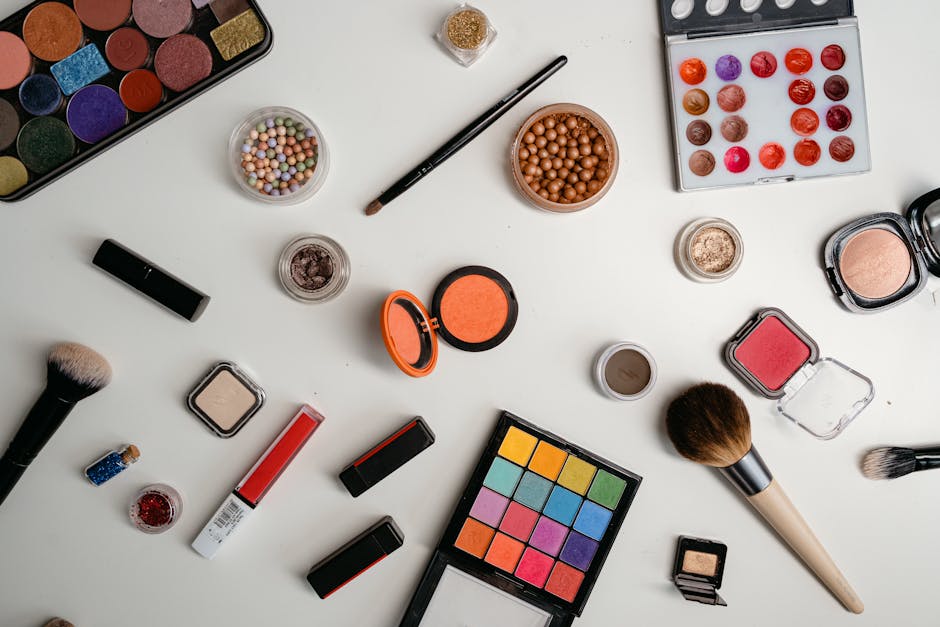 A vibrant collection of makeup and beauty products arranged in a flat lay on a white background